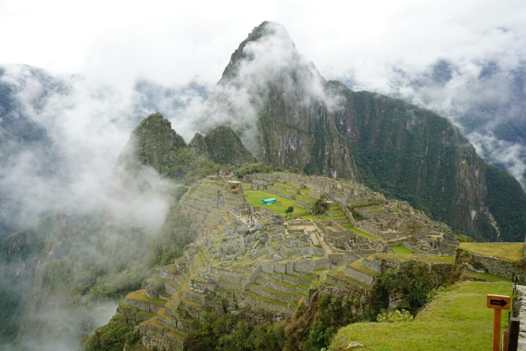 Machu picchu stands tall amidst the clouds.